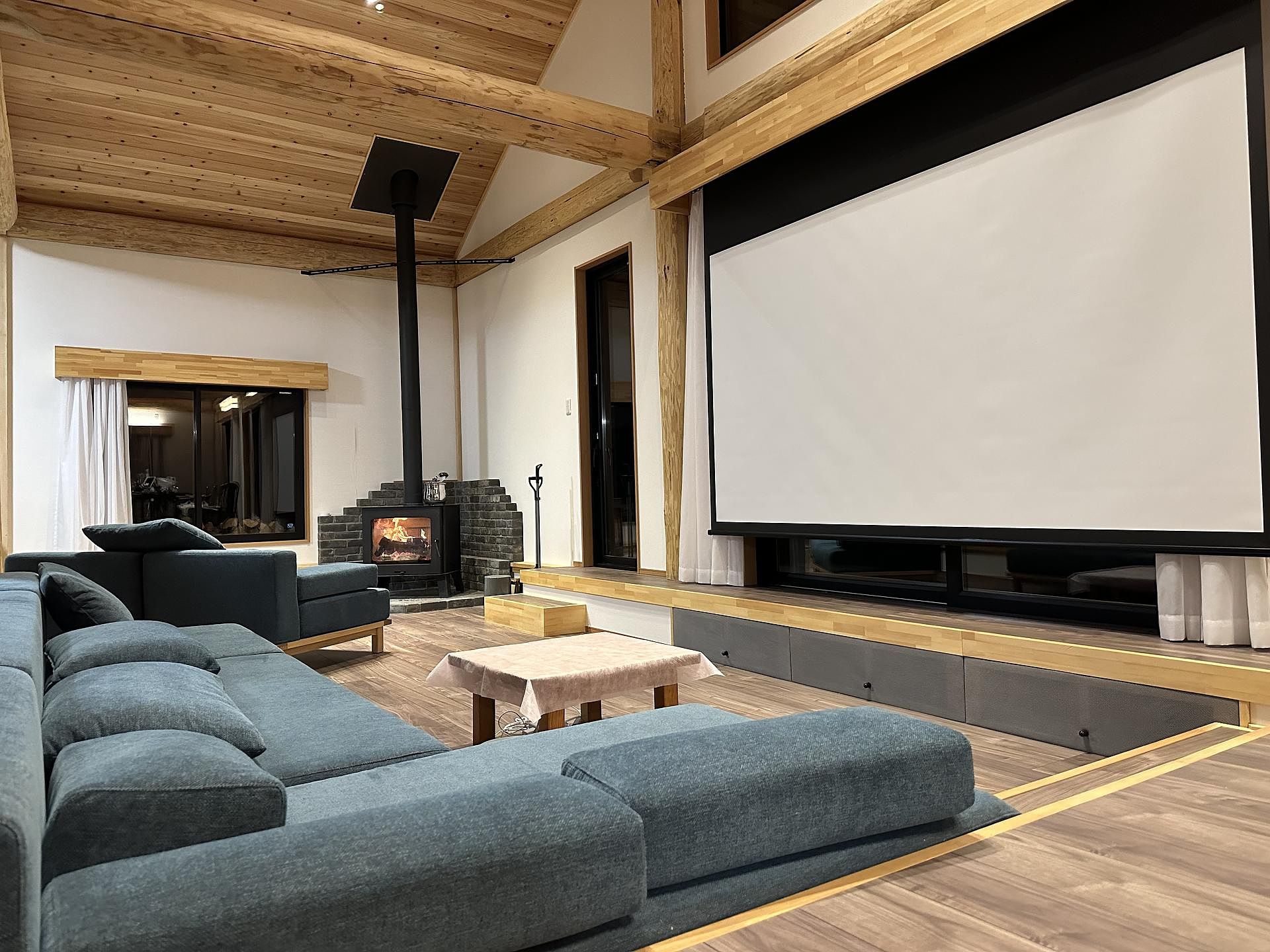 リビングソファと120インチスクリーン