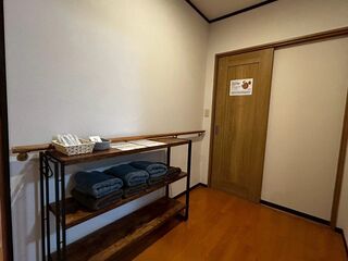 廊下にはタオル、施設案内、ハブラシなどが置いてある棚があります